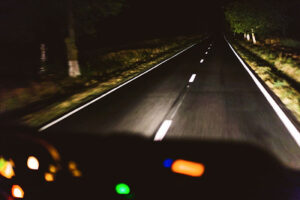 Car driving on dark road at night