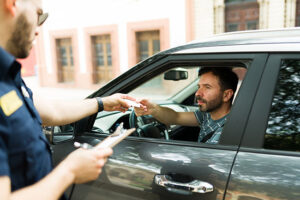 Policeman handing driver speeding ticket